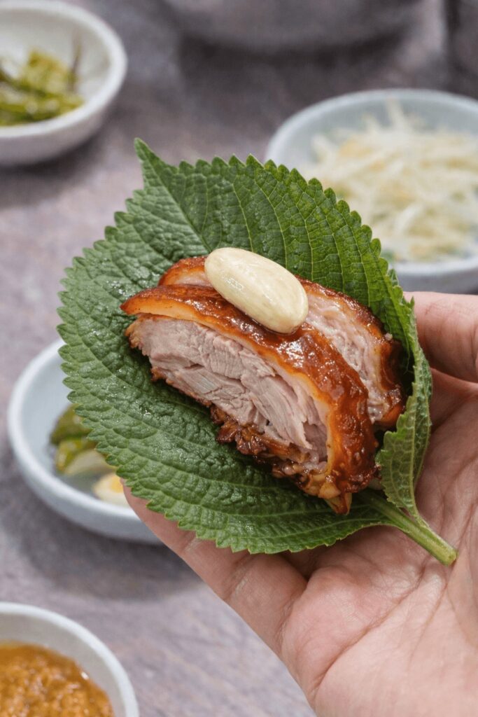 Korean jokbal wrapped in perilla leaf with garlic at Halmaejip Jokbal in Jongno