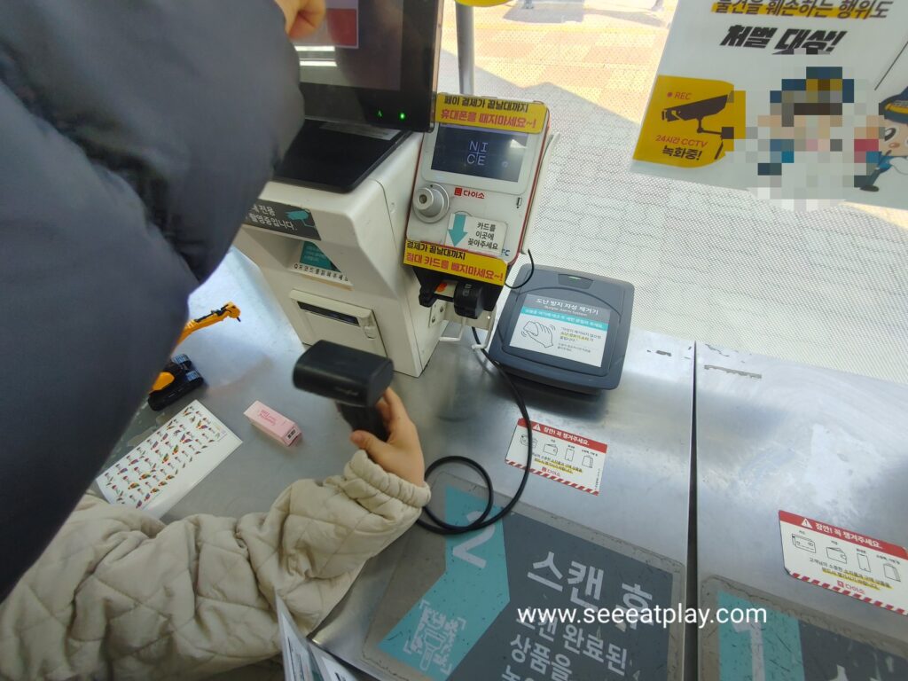 Customer scanning items at a self checkout machine inside Daiso Korea