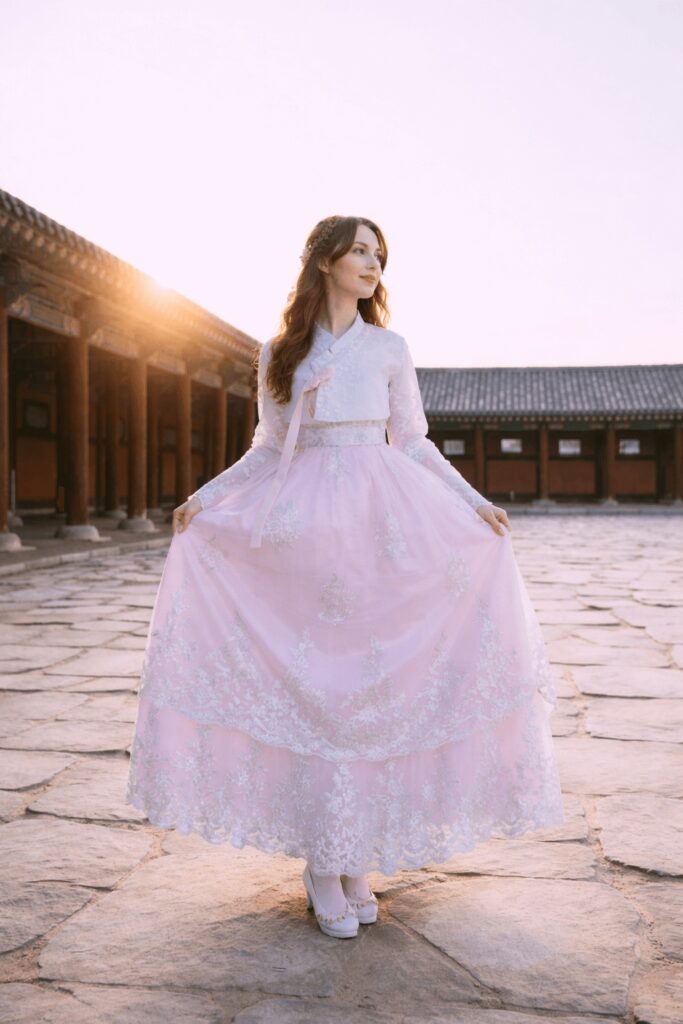 Traveler wearing pink hanbok taking photos at Gyeongbokgung Palace courtyard