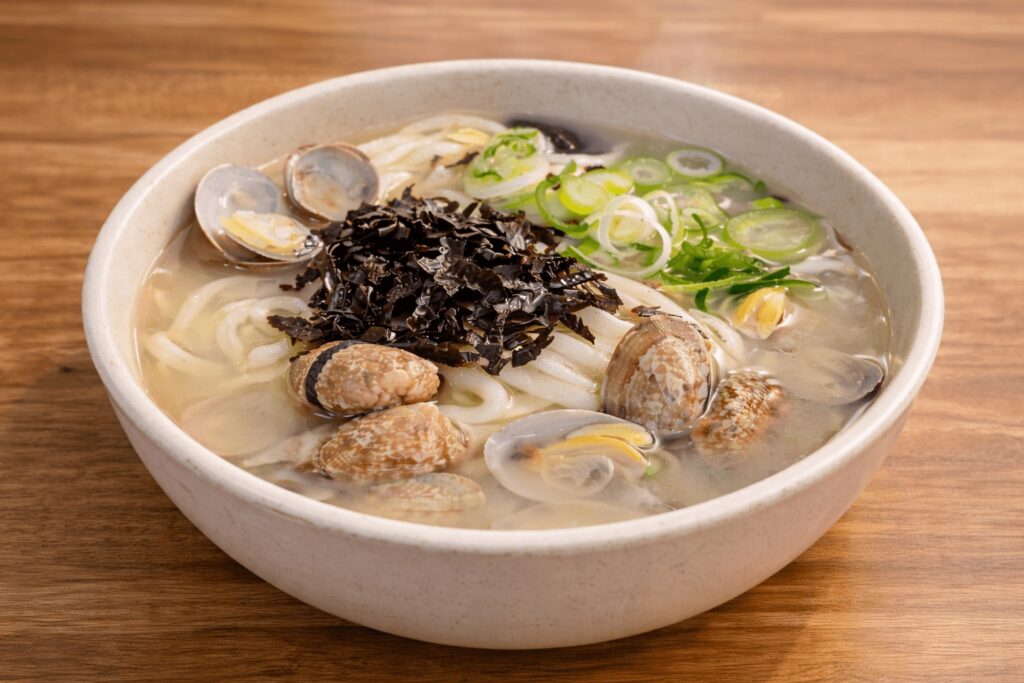 Close up of seafood kalguksu with clams and seaweed at Chanyangjip
