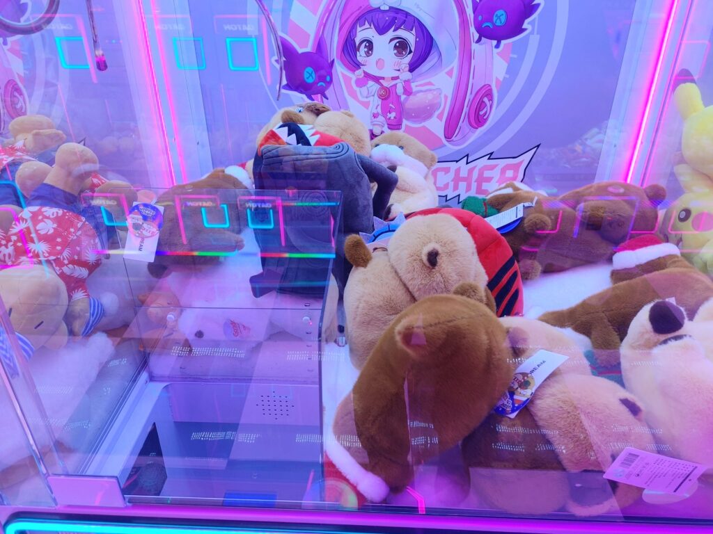 Close-up of claw machine with plush toys slightly messy for better chances
