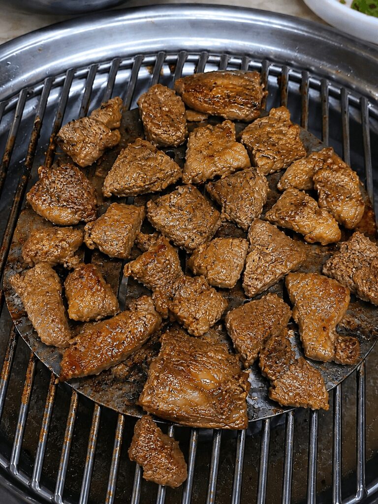Charcoal grilled pork galbi cooking at Jongno Korean BBQ restaurant