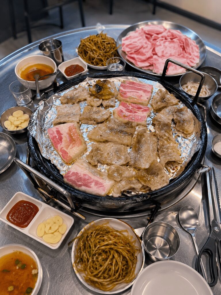 Frozen pork belly and beef brisket grilling on a Korean BBQ table at Hando Samgyeopsal in Jongno Seoul