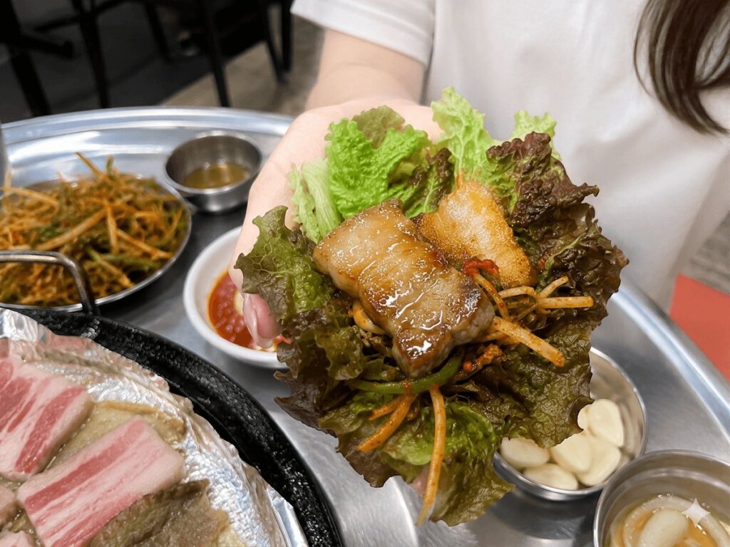 Korean pork belly lettuce wrap with green onion salad and garlic at Hando Samgyeopsal in Jongno  