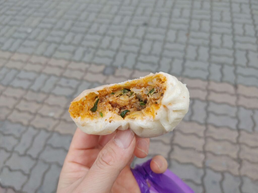 Kimchi wang mandu bitten showing spicy filling Jongno Seoul street food