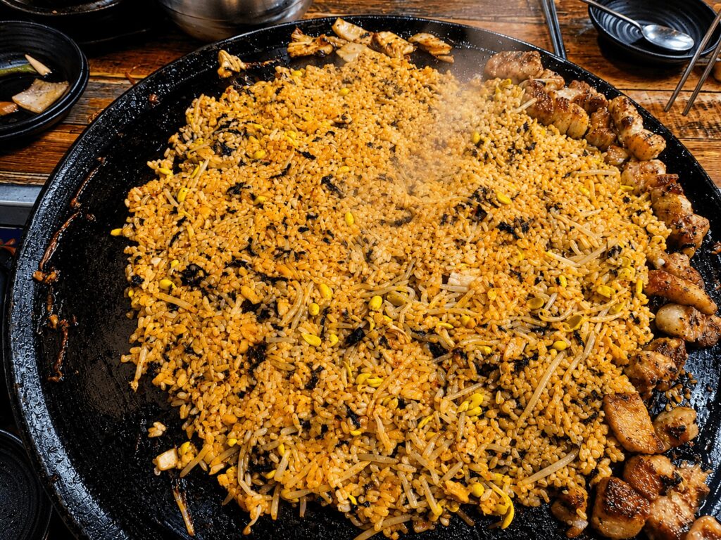 Korean fried rice 볶음밥 cooked on a Korean BBQ grill with kimchi bean sprouts and seaweed