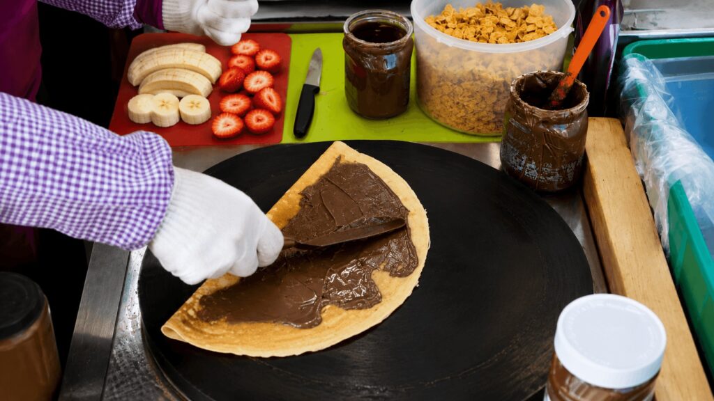 Korean street crepe being cooked with Nutella and fresh fruit in Dongdaemun Seoul