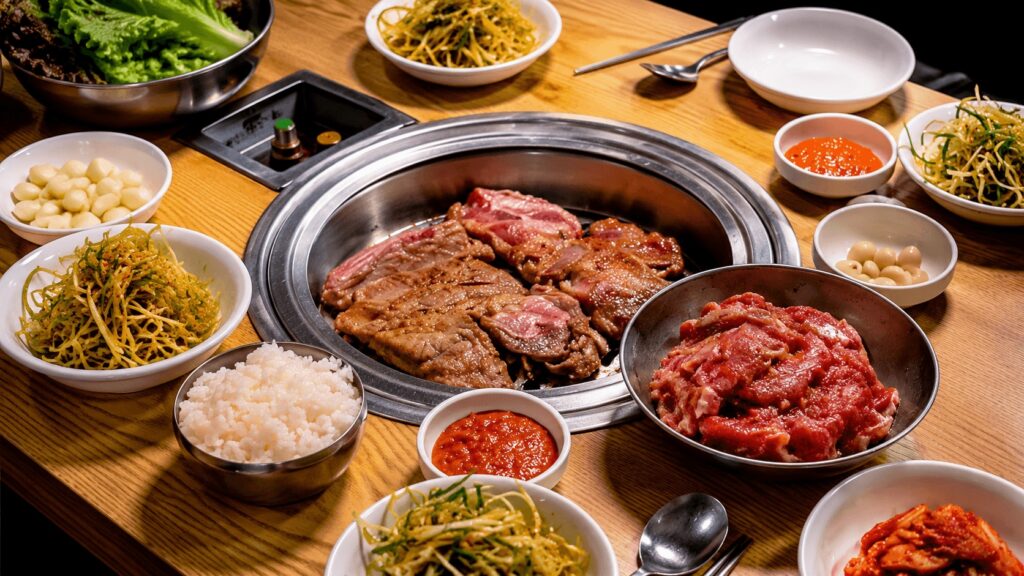 Korean pork galbi served with rice, garlic, vegetables, and Korean side dishes