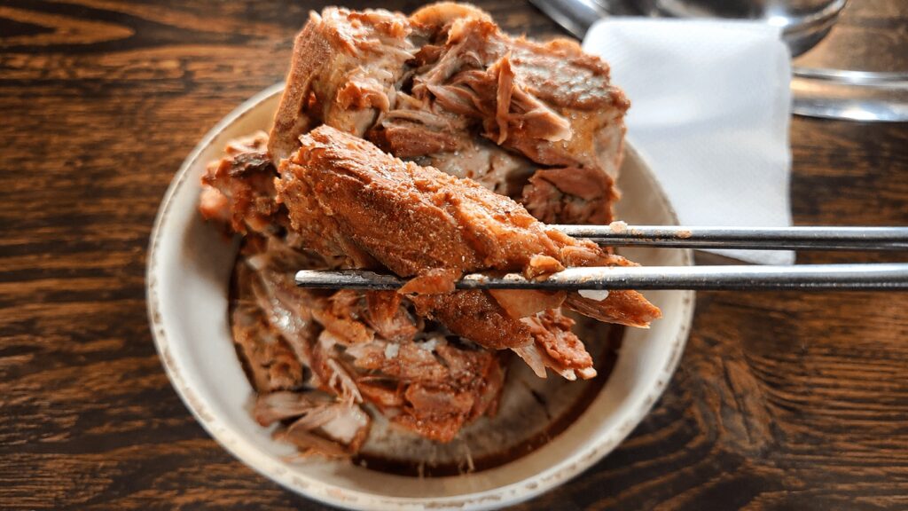 Tender pork meat picked with chopsticks from gamjatang in Seongsu, Seoul
