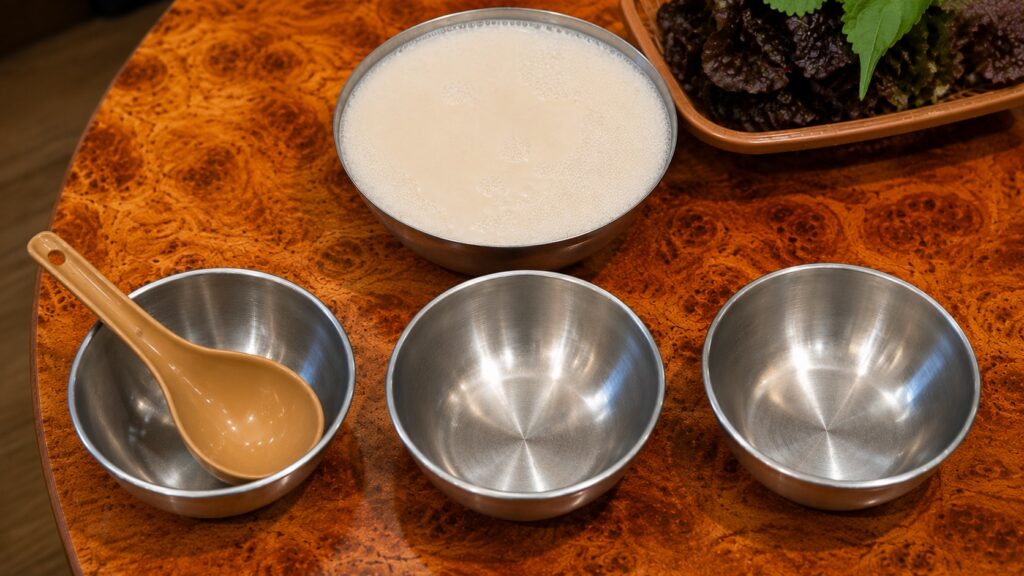 Traditional Korean makgeolli served in a metal bowl at a local restaurant near Seongsu