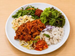 Korean buffet plate with spicy stir-fried pork, rice, salad, and side dishes at Seongsu Jeongchan Korean Buffet