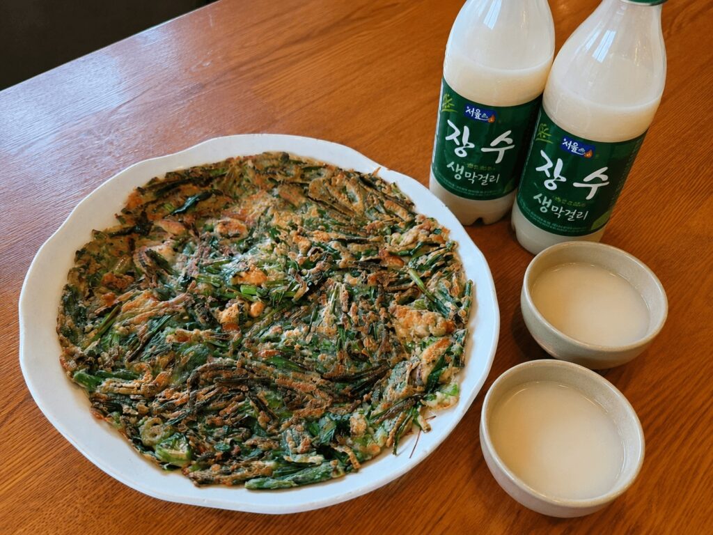 Korean seafood pajeon served with traditional makgeolli at a local jeon restaurant near Seongsu Station.