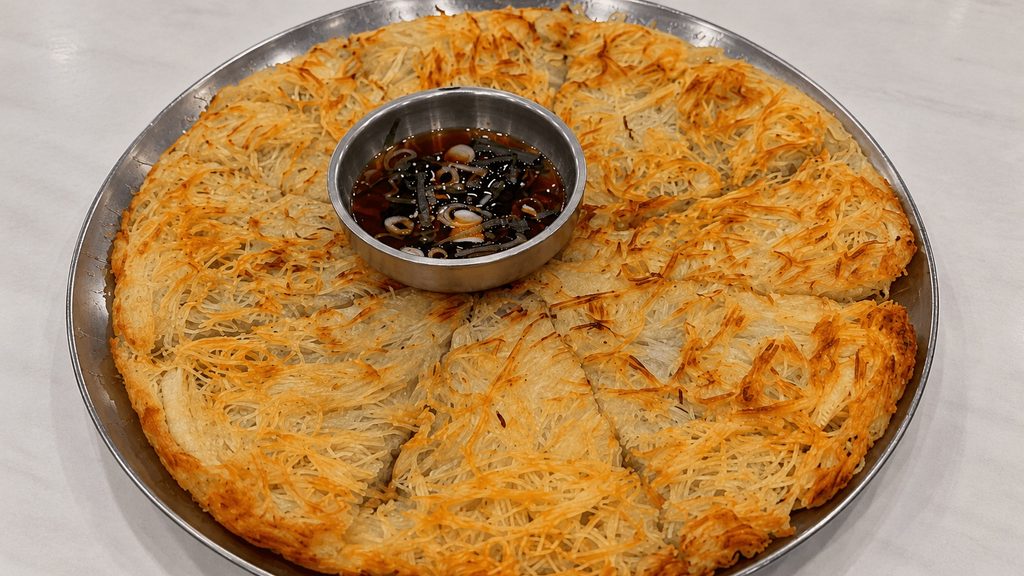 Crispy Korean potato pancake with dipping sauce at Hyodam