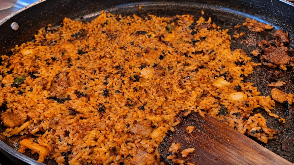 Korean spicy fried rice with seaweed and vegetables in a pan